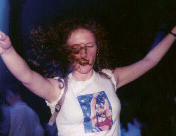 Jeune fille aux cheveux bouclés portant un tee-shirt manga qui danse dans la greenroom aux Trans Musicales 1995 lors d'une soirée Planète