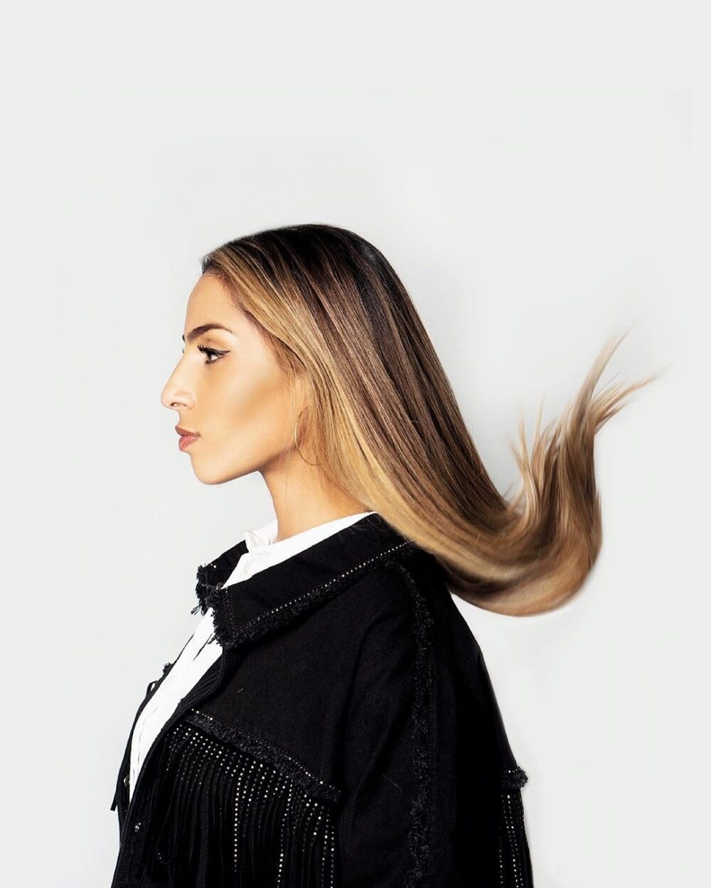 Portrait d'une jeune femme de profil avec les cheveux qui s'envolent