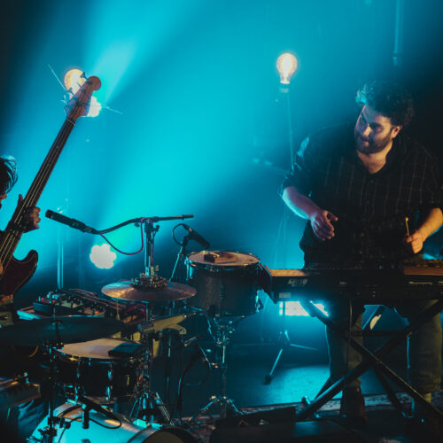 Les musiciens jouent sur scène dans une lumière bleutée