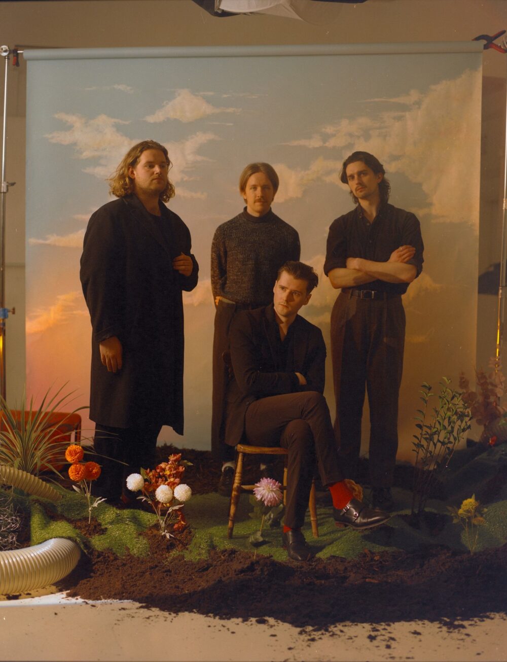 Portrait de quatre personnes devant un faux décor de nature