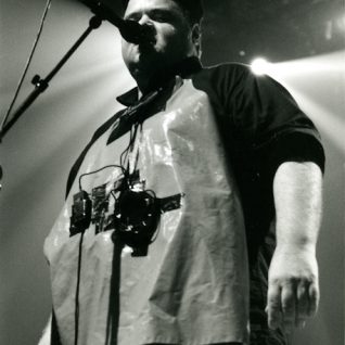 Photo en noir et blanc d'un chanteur habillé comme une sorte de boucher