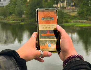 Gros plan sur des mains tenant un smartphone avec l'application du festival sur l'écran