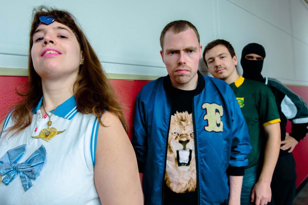 Portrait des quatre artistes les uns à la suite des autres avec des tenues excentriques