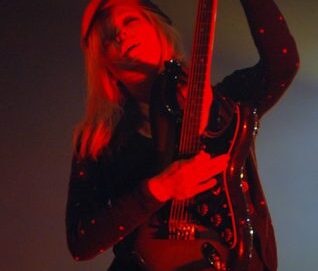 Jeune femme jouant de la guitare tenue à la verticale