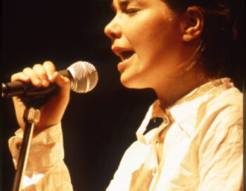 L'artiste chante les yeux fermés en tenant le micro