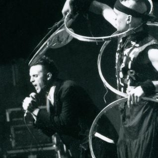 Photo noir et blanc d'un chanteur criant dans le micro et d'un artiste jonglant avec des cerceaux