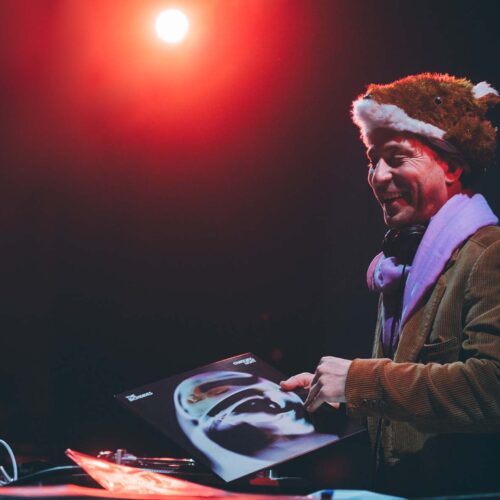 Un DJ avec un bonnet en forme de renard sourit