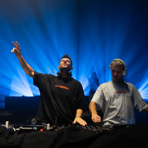 Deux DJ en action dont un lève le bras