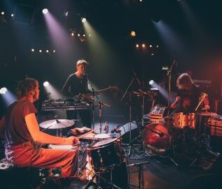 Photo de trois artistes musiciens et chanteurs sur scène