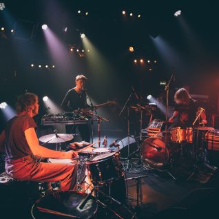 Photo de trois artistes musiciens et chanteurs sur scène