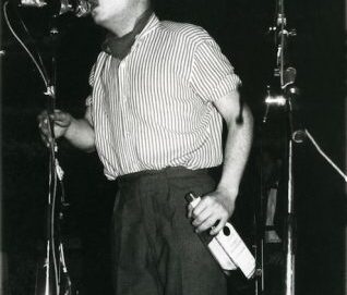 Photo en noir et blanc d'un chanteur tenant une bouteille à la main
