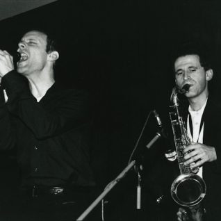 Photo en noir et blanc d'un chanteur et un saxophoniste