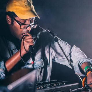 Un artiste manipule une console son en même temps qu'il chante