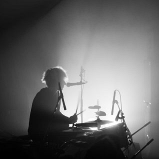 Photo en noir et blanc et en contre-jour d'un batteur