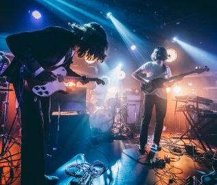 Photo d'une scène avec deux guitaristes