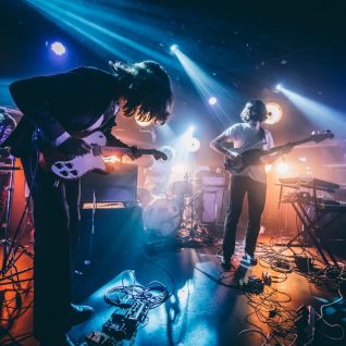 Photo d'une scène avec deux guitaristes